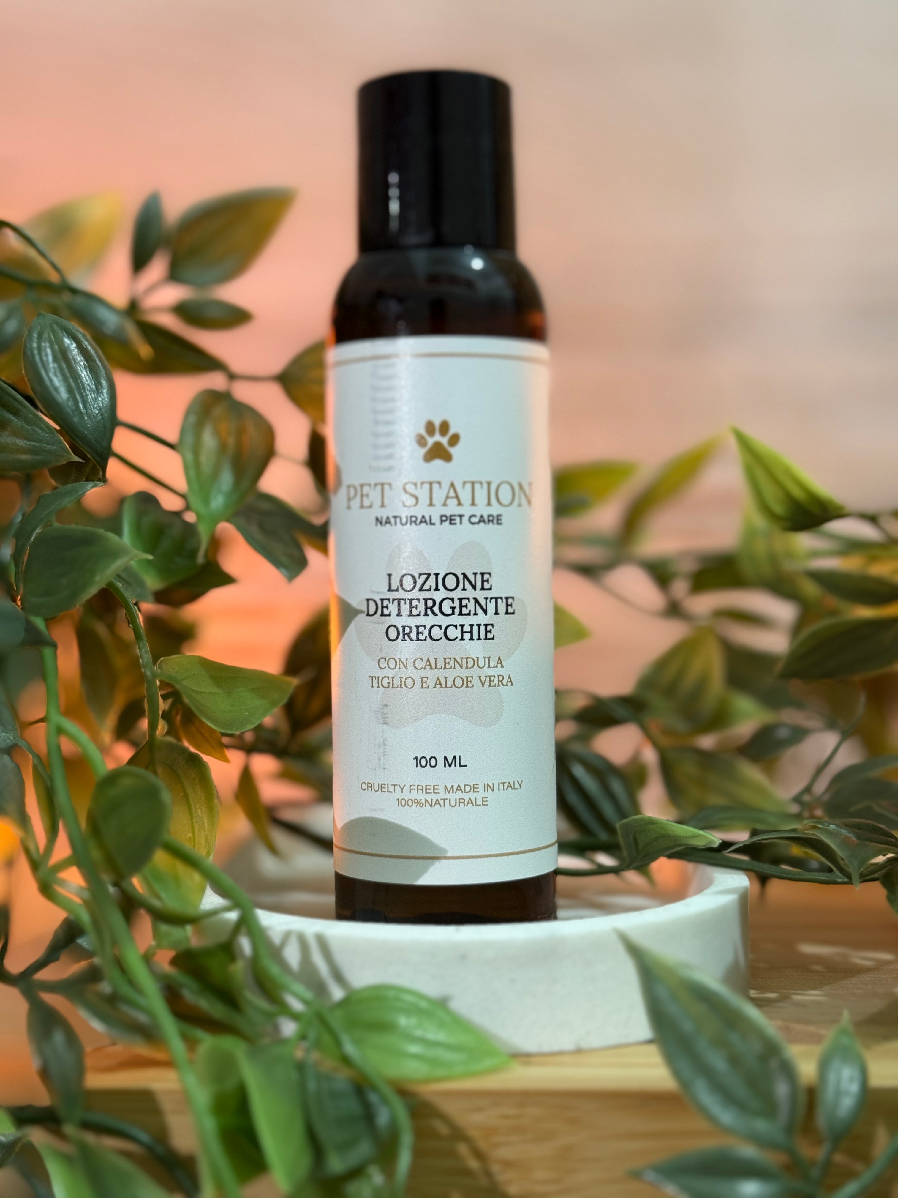 Lozione Detergente Orecchie – Calendula, Tiglio & Aloe Vera – 100 ml in un flacone circondato da piante decorative.